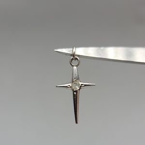 Sterling silver cross charm with a white stone